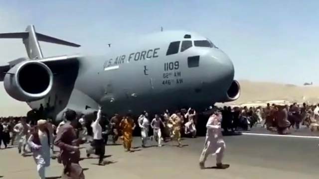 Pemandangan mengerikan ketika ratusan warga Afghanistan mengecar pesawat jet C-17 milik militer AS yang hendak take off. Beberapa orang nekat naik ke badan luar pesawat dan jatuh ketika pesawat mengudara. Salah satunya adalah pemain bola Aghanistan, Zaki Anwari. (AP Photo/Al Jazeera)