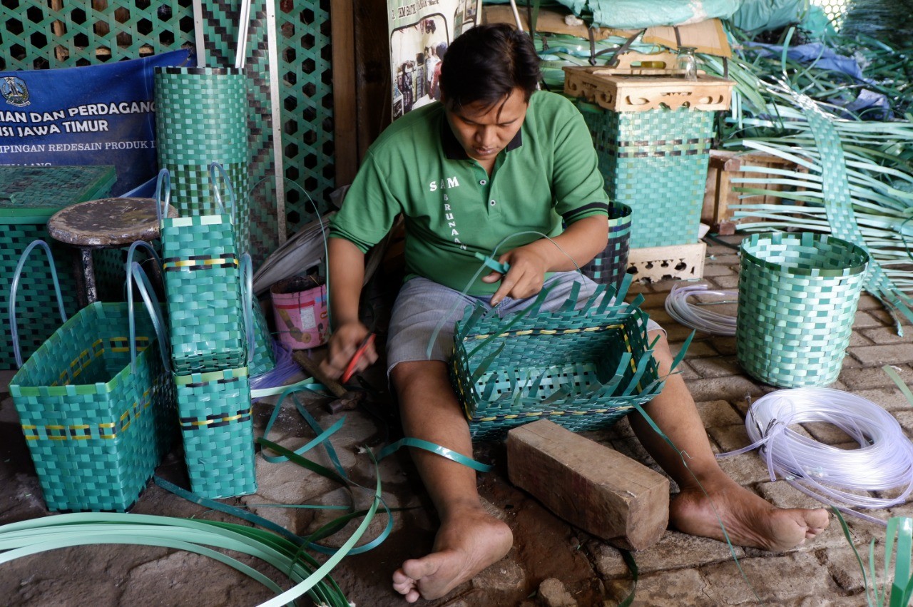 Salah seorang pekerja sedang menganyam limbah plastik di di tempat usaha Sam Brunang, Kota Probolinggo. (Foto: Ikhsan Mahmudi/Ngopibareng.id)