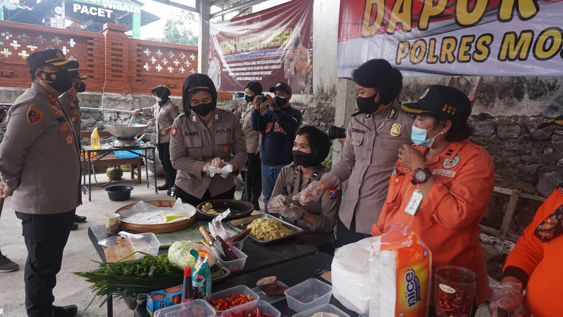 Polwan Polres Mojokerto bersama relawan saat memasak di dapur umum.(Foto: Deni Lukmantara/Ngopibareng)