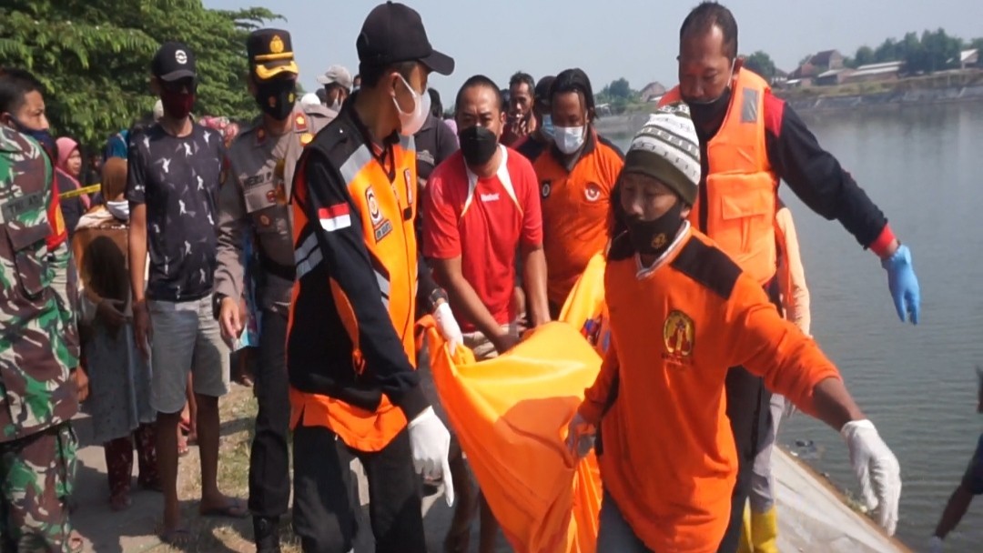 Polisi dibantu relawan saat mengevakuasi jasad korban dari Waduk Long Storage. (Foto: Deni Lukmantara/Ngopibareng.id)