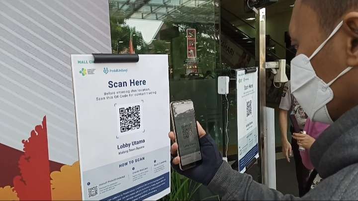 Salah satu pengunjung Malang Town Square saat melakukan scanning barcode aplikasi PeduliLindungi. (Foto: Lalu Theo/ngopibareng.id)