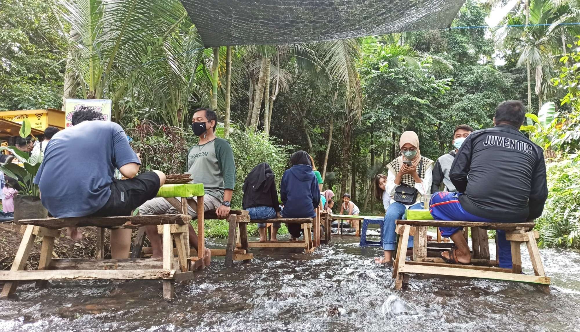 Sejumlah pengunjung menikmati suasana di Warung Kali Sodong (foto:Muh Hujaini/Ngopibareng.id)