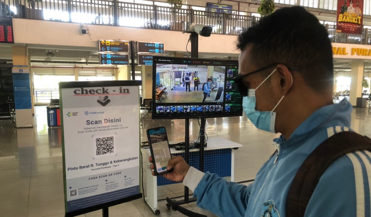 Penumpang bus di Terminal Purabaya alias Bungurasih melakukan scan barcode. (Foto: Andhi Dwi/Ngopibareng.id)