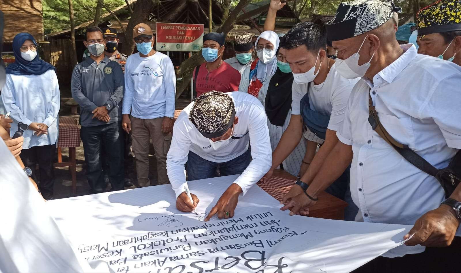 Ketua Asoiasi Pokdarwis Banyuwangi, Abdul Azis, menandatangani komitmen bersama mentaati protokol kesehatan. (Foto: Muh Hujaini/Ngopibareng.id)