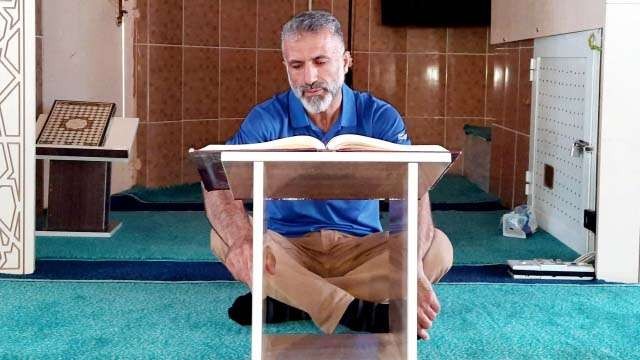 Yassin M Aref, 51 tahun,  sedang membaca Al Quran di masjidnya di wilayah Kurdi di Irak utara. (Foto: Dana Taib Menmy/Al Jazeera)