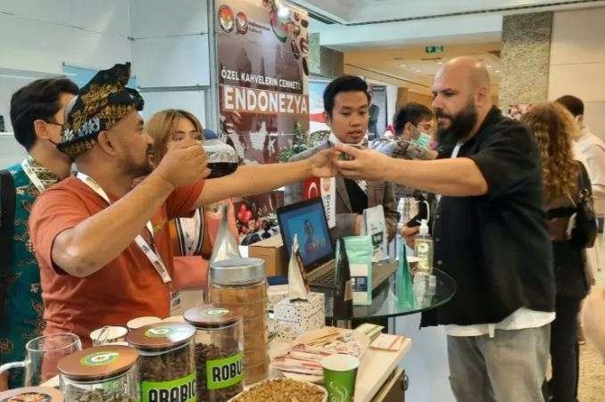 Barista dari Indonesia menyerahkan segelas kopi kepada pengunjung di pameran kopi Coffex Istanbul 2021. Melalui tajuk Heaven of Specialty Coffee sukses menarik minat pengunjung dan menedapatkan komitmen pembelian 30 kontainer atau 600 ton biji kopi melalui pameran tersebut di Istanbul, Turki. (KJRI Istanbul)