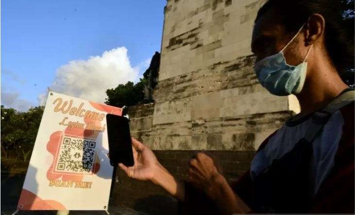 Wisatawan memindai QR Code saat akan memasuki kawasan wisata Pantai Legian, Badung, Bali. (Foto: Antara/Naufal Fikri Yusuf)