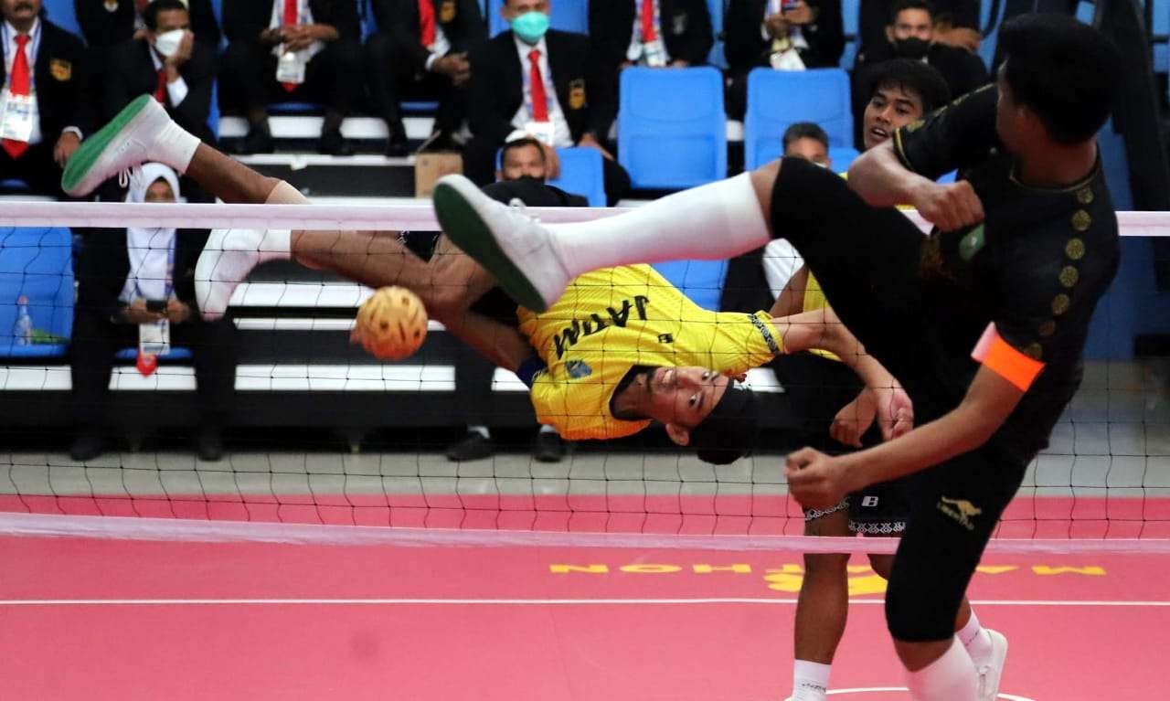 Atlet Sepak Takraw Jatim (kuning) melakukan serangan ke arah permainan Papua di GOR Trikora Universitas Cendrawasih, Jayapura, Selasa 28 September 2021. (Foto: KONI Jatim)