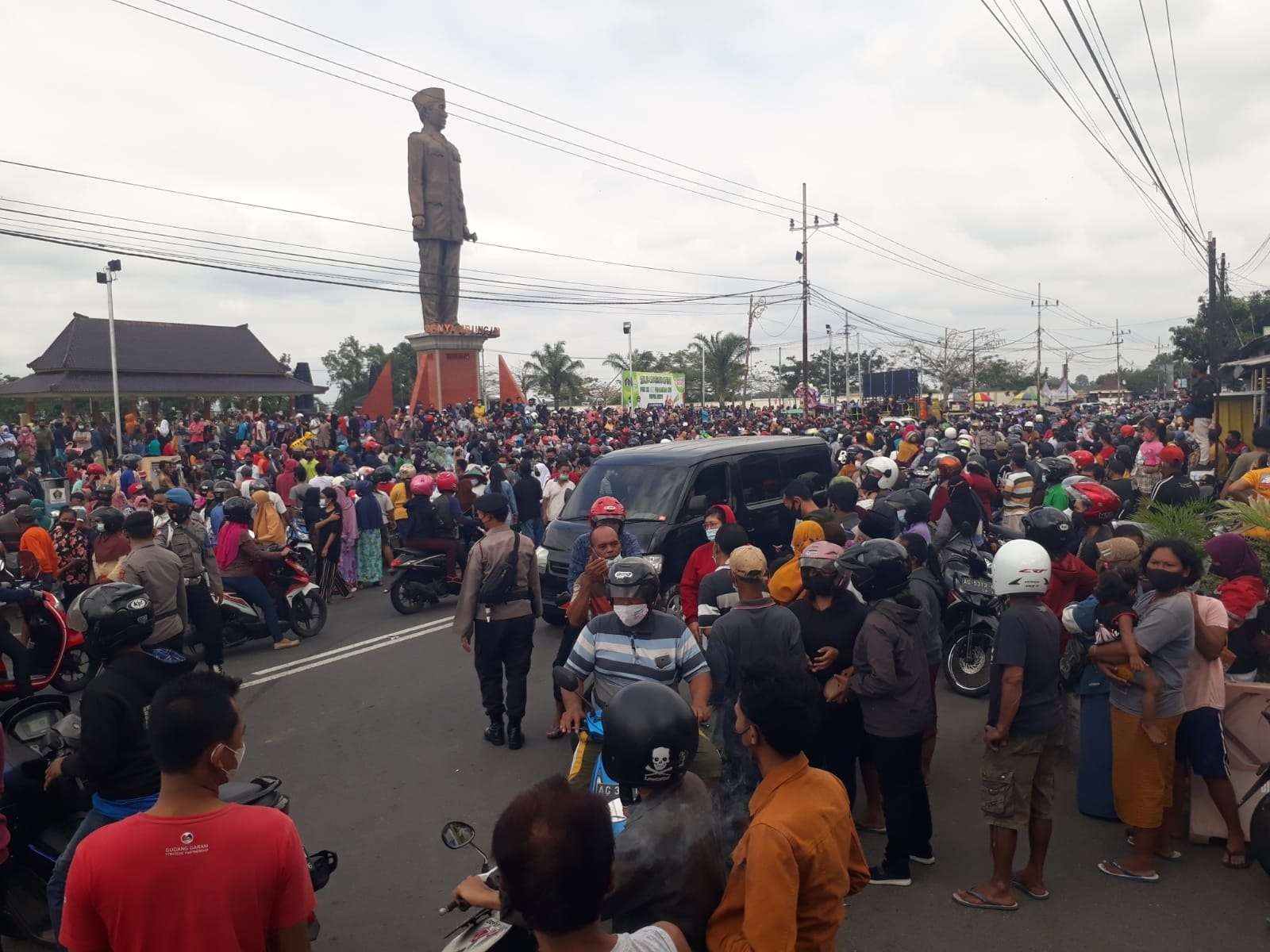 Warga berkerumun di Patung Bung Karno Blitar untuk menanti pembagian telur dan daging ayam gratis. (Foto: Choirul Anam/Ngopibareng.id)