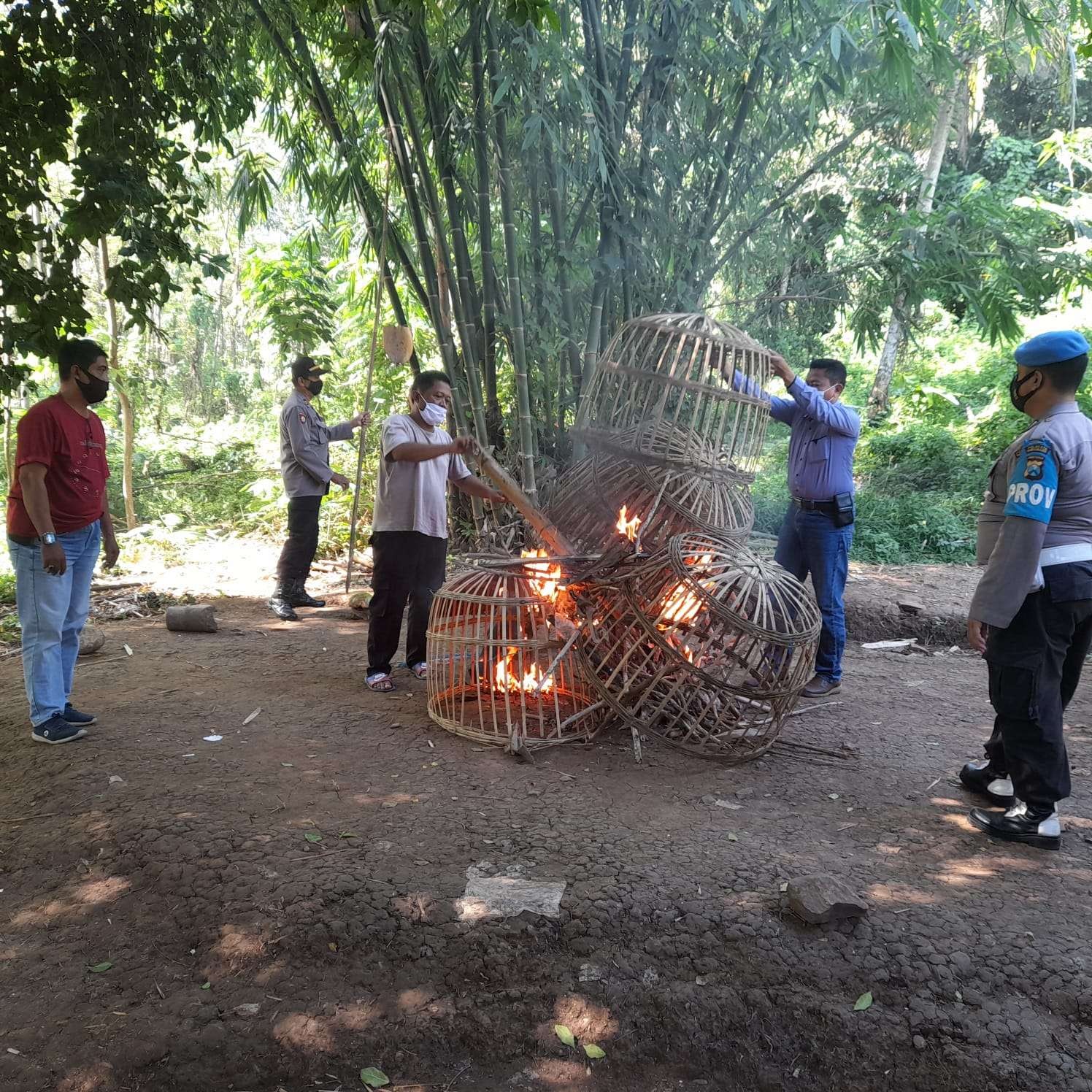 Petugas membakar barang-barang yang ditemukan di lokasi yang diduga kuat sebagai arena judi sabung ayam (foto:istimewa)