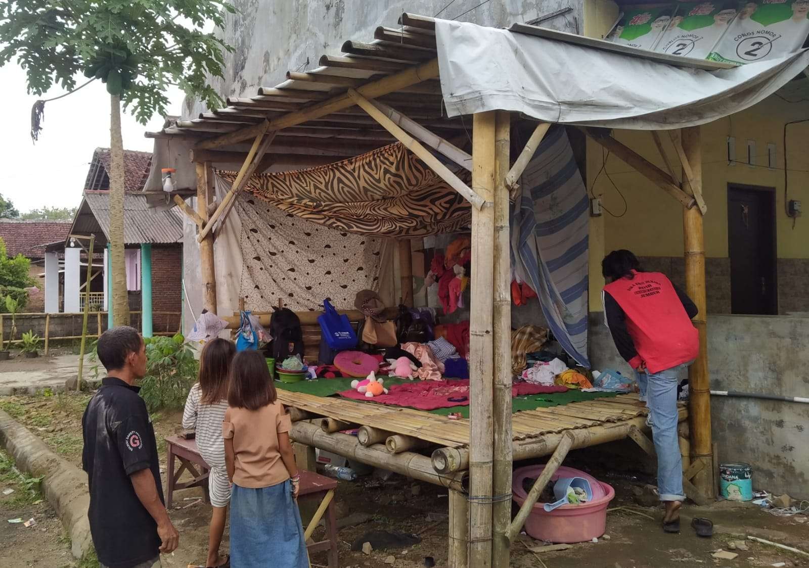 Solehudin bersama dua putrinya sedang persiapan mengangkat barang-barangnya sesaat sebelum Mispika Patrang datang (Foto: Rusdi/ngopibareng.id)