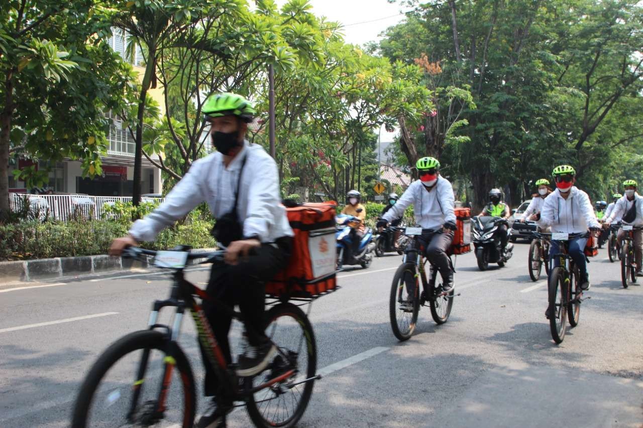 Rektor UBAYA Benny Lianto bersama beberapa mahasiswa Ngontel bareng untuk mengantarkan toga ke wisudawan. (Foto: istimewa)