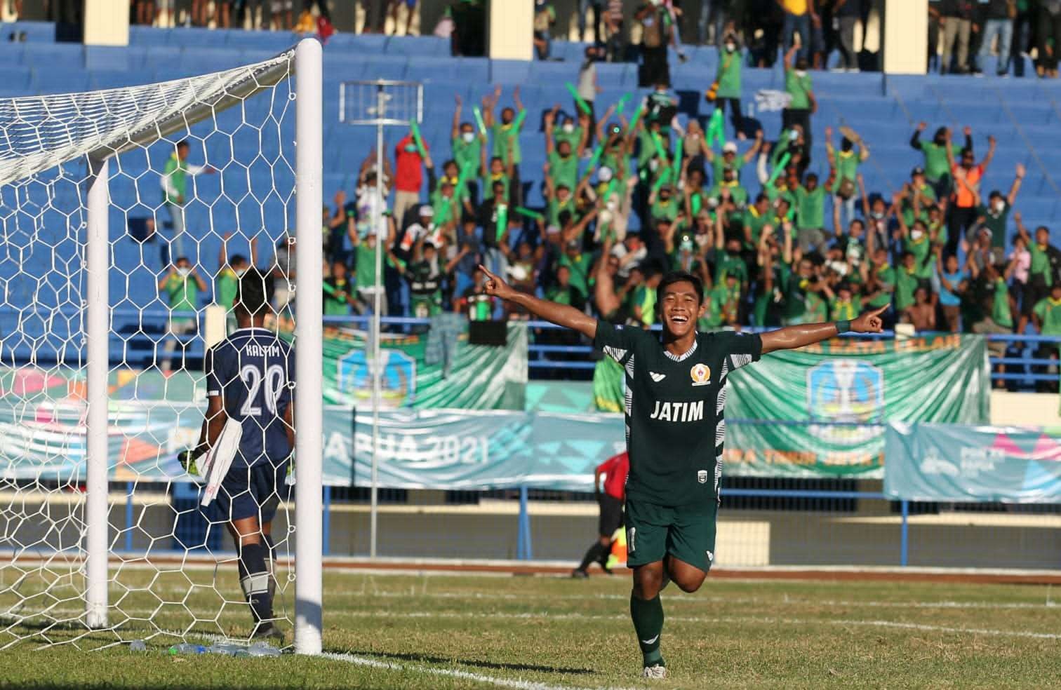 Pemain Jatim, Dwiki Mardianto melakukan selebrasi usai menjebol gawang Kaltim pada ajang PON XX 2021 Papua di Stadion Barnabas Youwe, Jayapura, Jumat 8 Oktober 2021. (Foto: Fariz Yarbo/Ngopibareng.id)