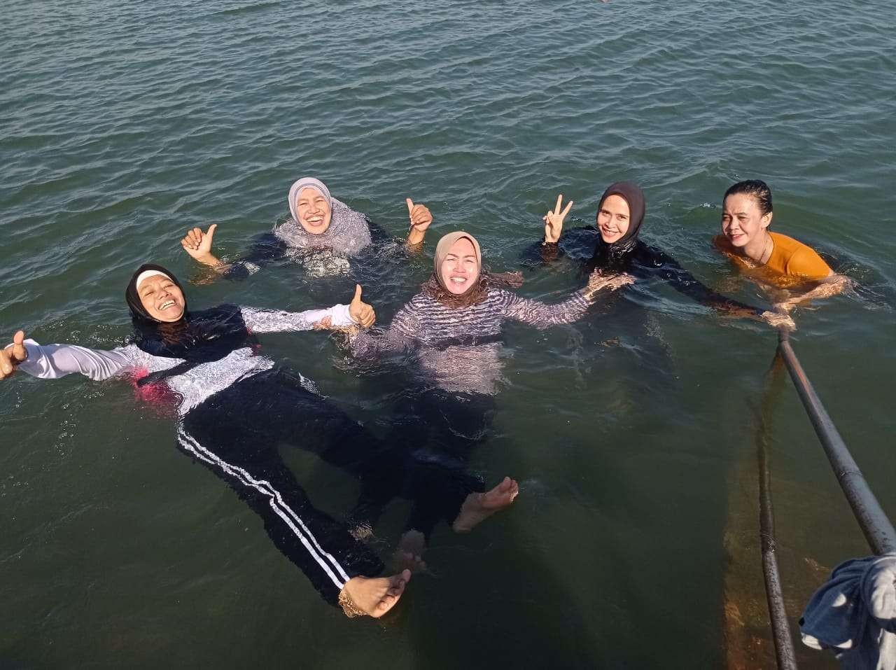 Sejumlah warga sedang berendam di kawasan Pelabuhan Perikanan Pantai (PPP) Mayangan, Kota Probolinggo. (Foto: Ikhsan Mahmudi/Ngopibareng.id)