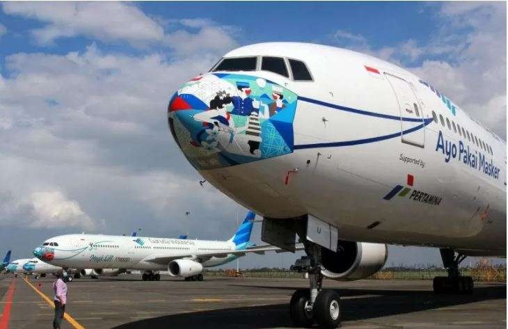 Pengunjung mengamati pesawat Garuda Indonesia bercorak khusus dengan visual masker pada bagian moncong pesawat di Hanggar GMF AeroAsia Bandara Soekarno Hatta, Tangerang, Banten, Selasa 8 Desember 2020. (Foto: Antara/Muhammad Iqbal)