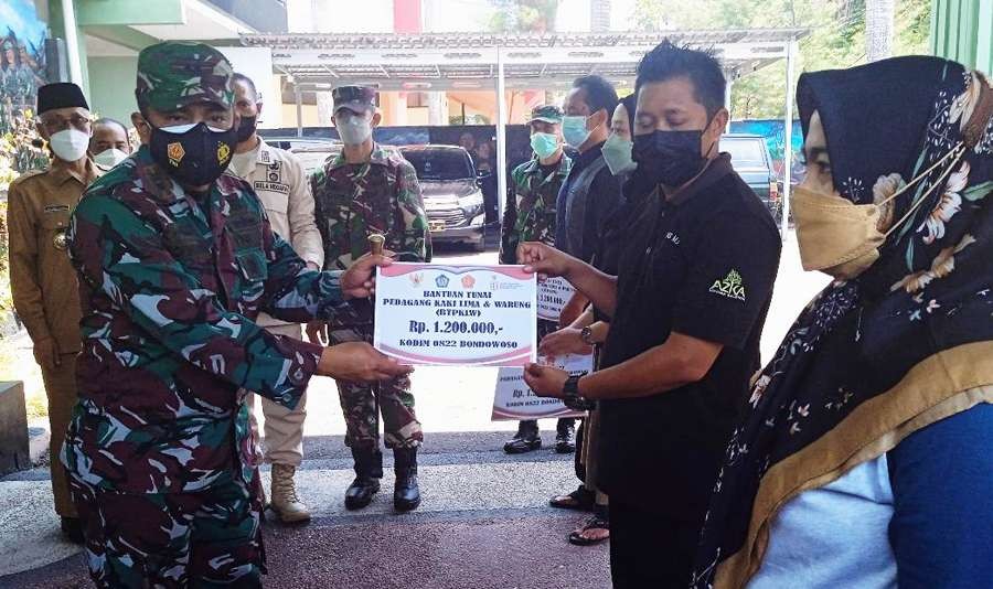 Dandim 0822 Bondowoso Letkol Kav.Widi Widayat menyerahkan bantuan tunai kepada perwakilan PKL dan pemilik warung di Makodim 0822, Senin 25 Oktober 2021.(Foto: Guido Saphan/Ngopibareng.id)