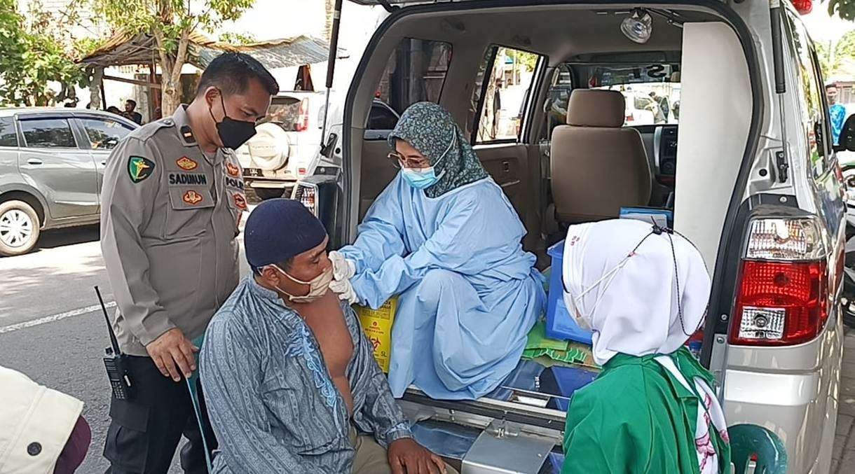 Salah seorang warga mendapatkan suntikan vaksinasi di gerai vaksinasi keliling Sidokkes Polresta Banyuwangi (foto :istimewa)