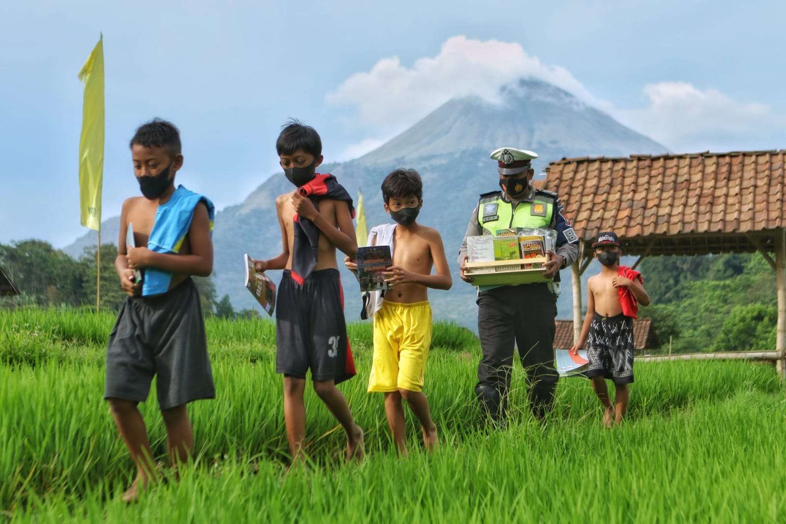 Aiptu Eriyantono mengajak anak-anak belajar di tengah area persawahan. (Foto: Deni Lukmantara/Ngopibareng.id)