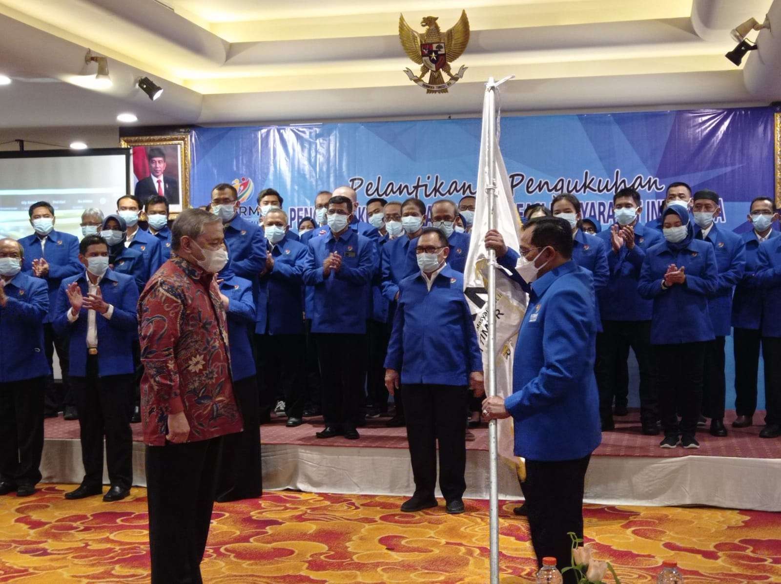 Ketua KORMI Jatim, Hudiono (kanan) menerima pataka yang diserahkan Ketua KORMI Pusat Hayono Isman. (Foto: Fariz Yarbo/Ngopibareng.id)