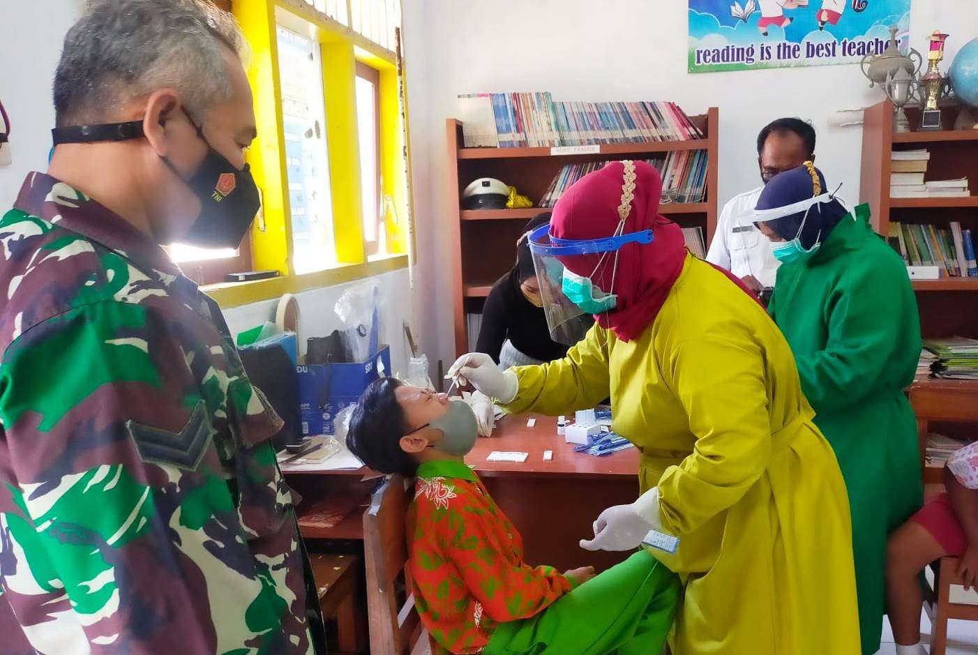 Petugas Puskesmas Paspan melakukan tes swab antigen pada siswa SD (foto:istimewa)