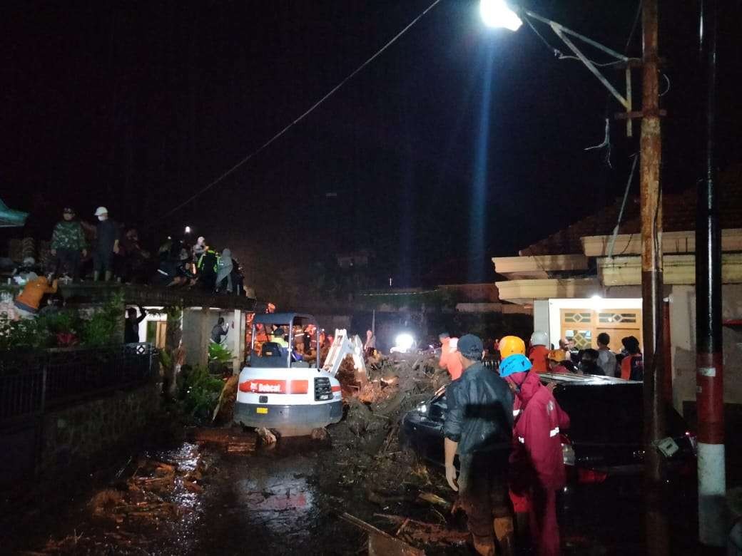 Petugas BPBD Kota Batu saat membersihkan material sisa banjir di Desa Bulukerto, Kota Batu (Foto: Lalu Theo/Ngopibareng.id)