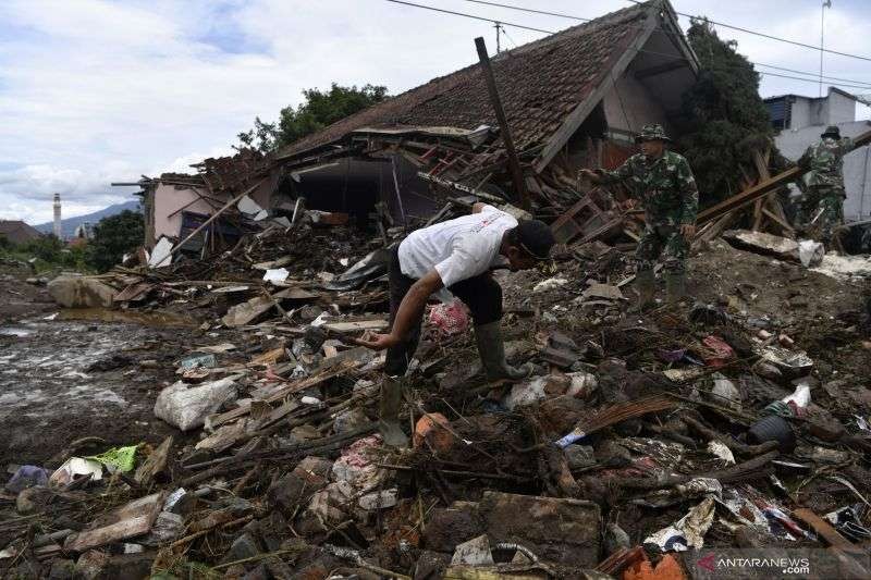 TNI dan relawan Tim SAR membersihkan puing-puing rumah rusak akibat banjir bandang di Batu. (Foto: Ant)