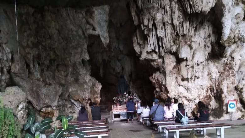 Gua Maria Tritis di bukti Gunung Kidul, tampak beberapa orang sedang berdoa (Foto: Asmanu Sudarso/ngopibareng.id))