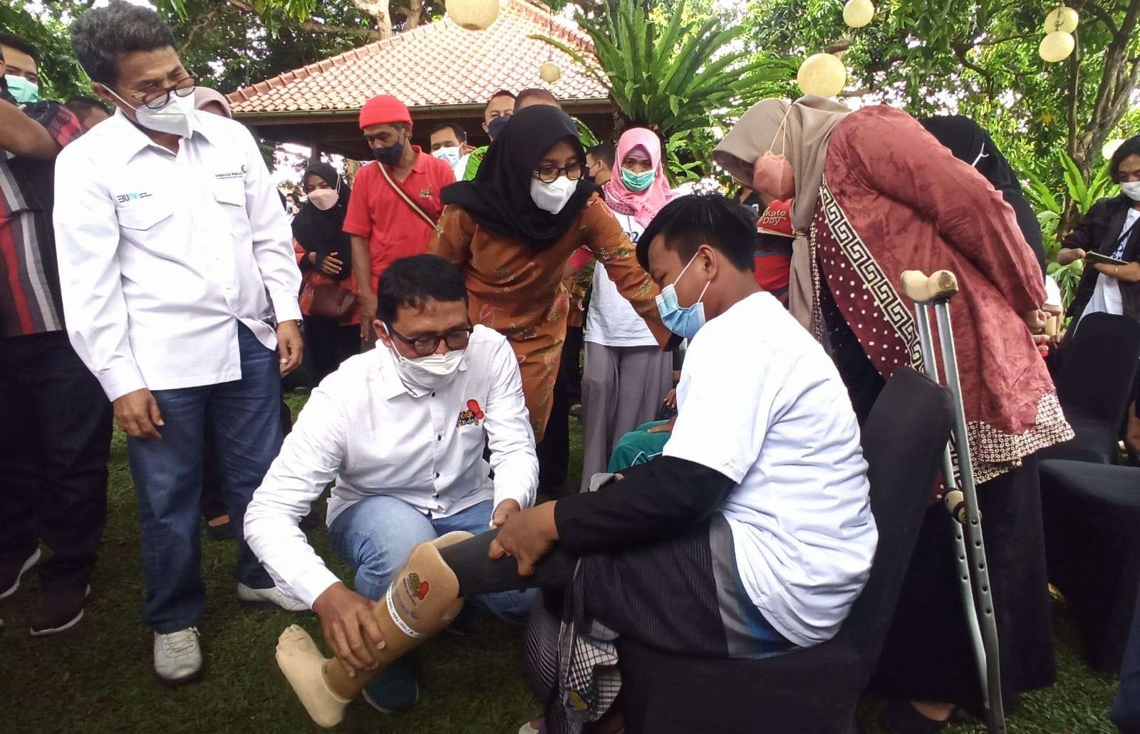 Bupati Banyuwangi Ipuk Fiestiadnani bersama Senior General Manager of Community Development Center PT Angkasa Pura 2, Amirzal, menyaksikan pemasangan kaki palsu pada penerima bantuan. (Foto: Muh Hujaini/Ngopibareng.id)