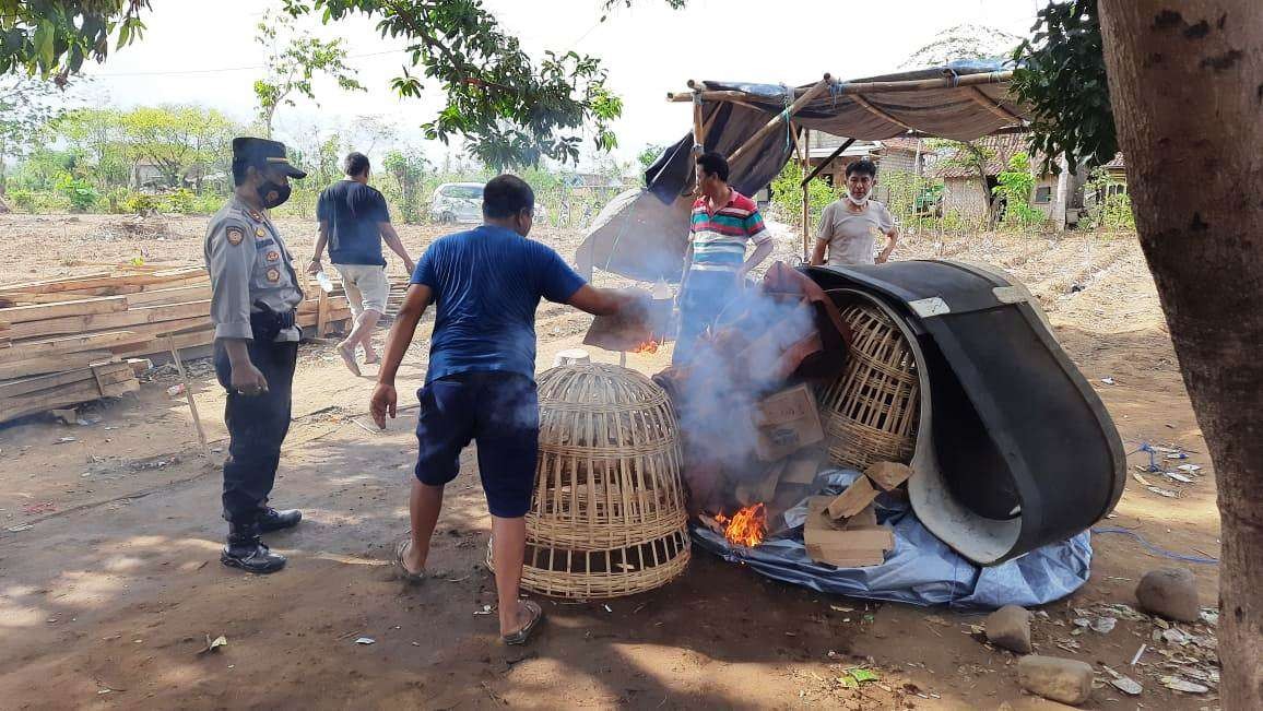 Petugas Kepolisian membakar barang-barang yang ditemukan di arena judi sabung ayam (foto:istimewa)