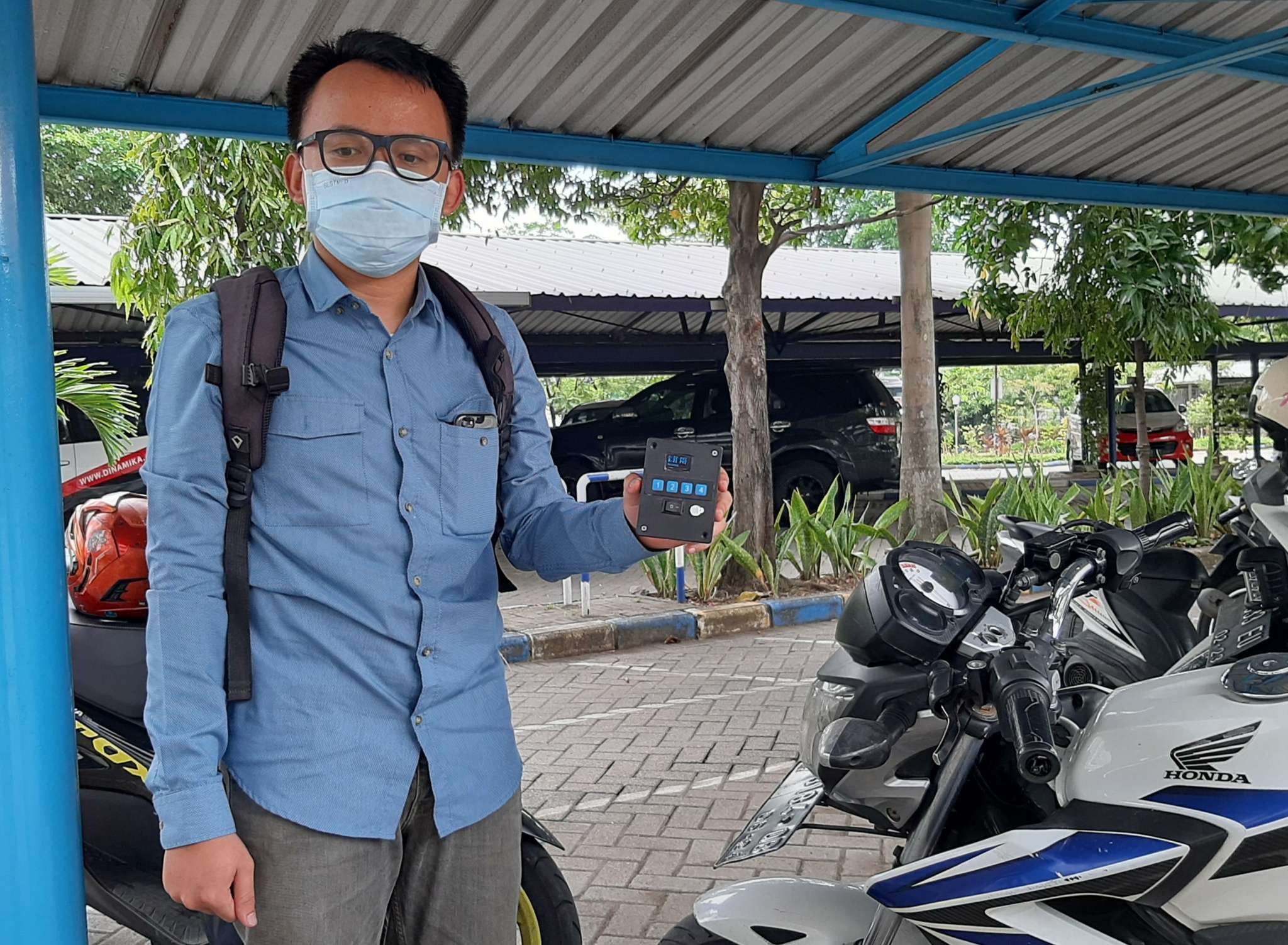 Satria Adi Muhammad saat menunjukkan alat pendeteksi tekanan angin ban yang bisa digunakan pada motor. (Foto: Pita Sari/Ngopibareng.id)