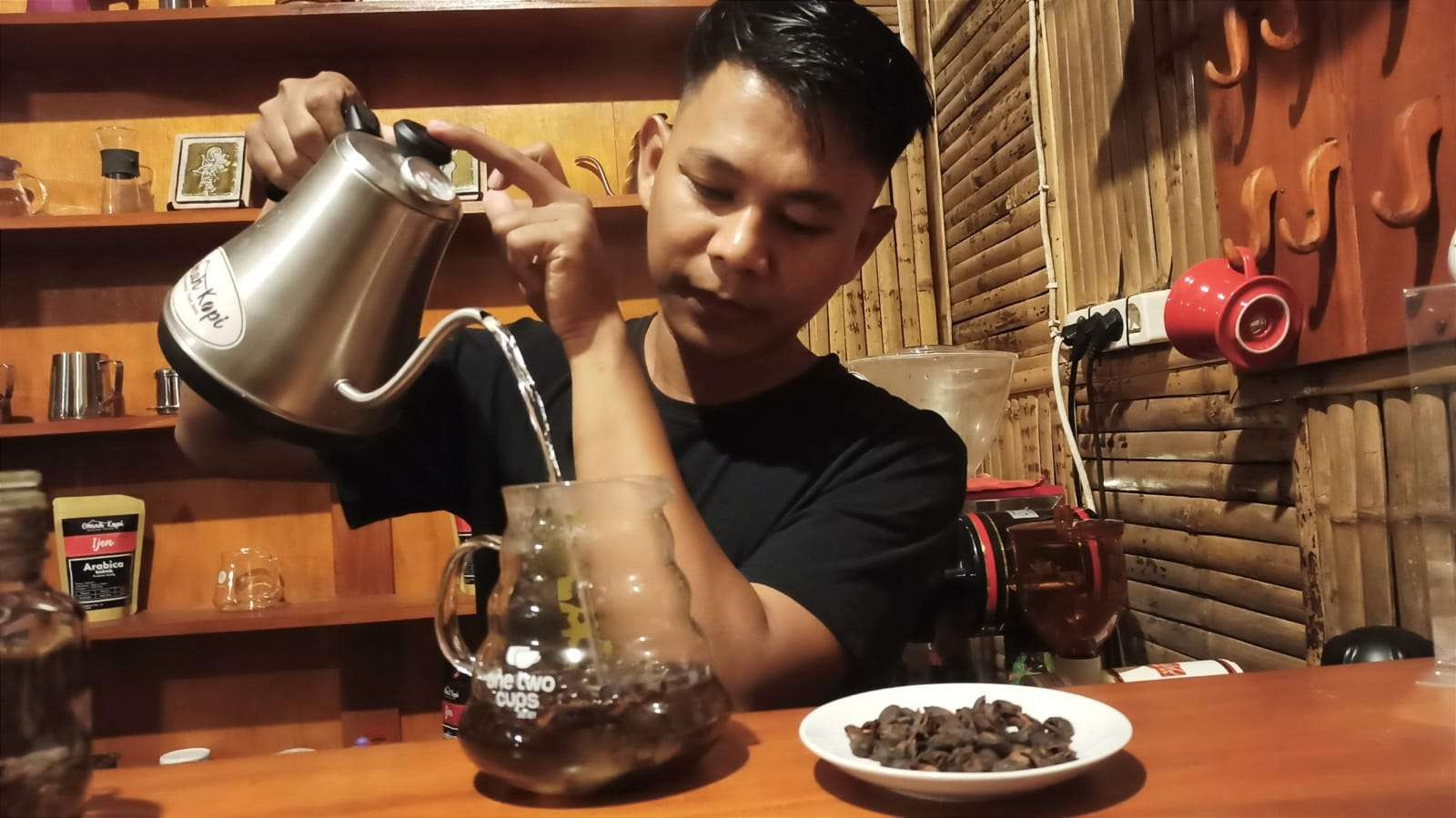 Imam Mukhlis sedang menyeduh teh kulit kopi atau cascara (foto: Muh Hujaini/Ngopibareng.id)