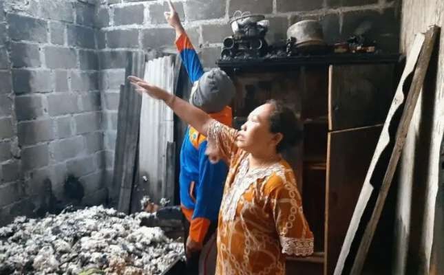 Pasangan suami istri Saleh dan Yanuk, warga Desa Landangan, Kecamatan Kapongan, Situbondo, menunjukkan kondisi kamar rumahnya hangus terbakar. (Foto: BPBD Situbondo)