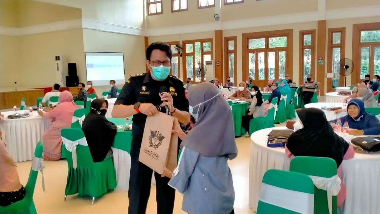 Nangkok P. Pasaribu, narasumber dari Bea Cukai Probolinggo sedang memberikan tali asih kepada peserta sosialisasi yang berhasil menjawab pertanyaan. (Foto: Ikhsan Mahmudi/Ngopibareng.id)