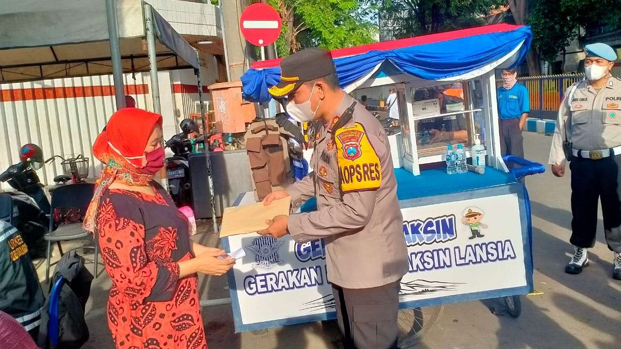 Kapolresta AKBP Wadi Sa'bani memberikan tali asih kepada warga usai divaksin. (Foto: Ikhsan Mahmudi/Ngopibareng.id)