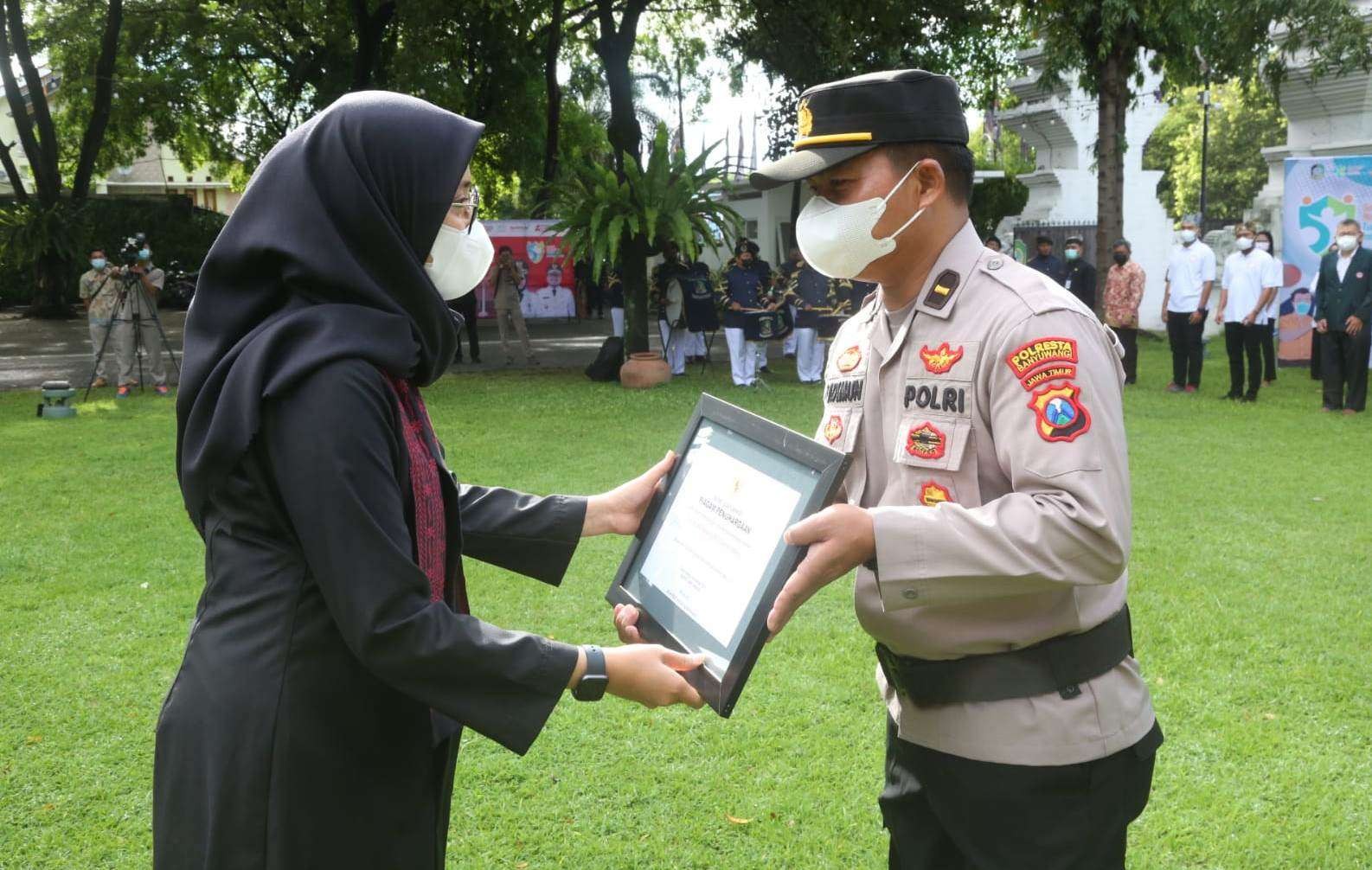 Bupati Banyuwangi Ipuk Fiestiandani menyerahkan penghargaan kepada Paurker Polresta Banyuwangi Ipda Sadimun (Foto: Istimewa)