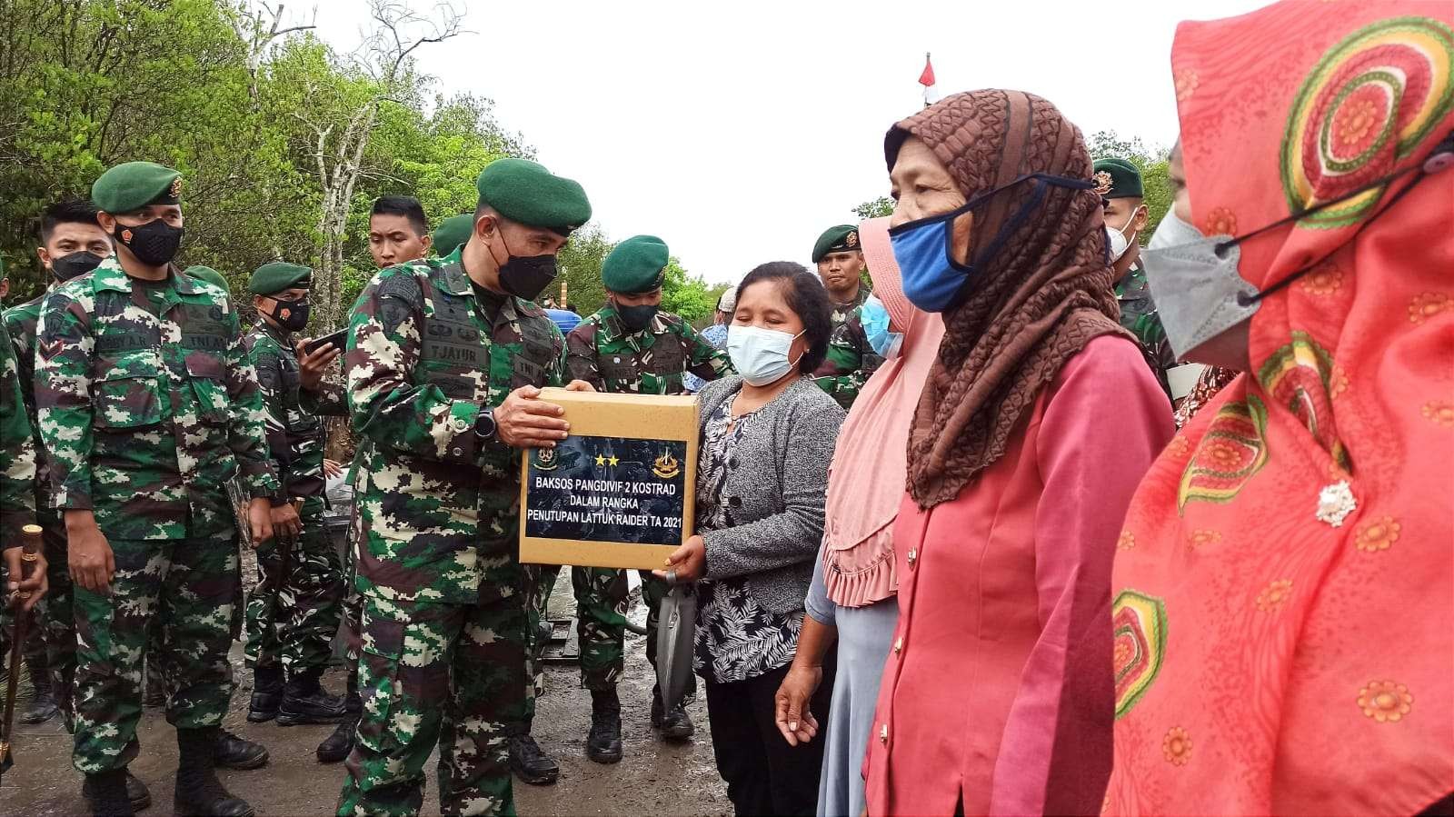 Kepala Staf Divif 2 Kostrad, Brigjen TNI Tjaturputra Gunadi Genah menyerahkan bantuan sosial kepada warga di Banyuwangi. (Foto: Muh Hujaini/Ngopibareng.id)