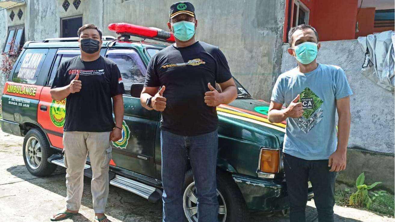 Rujul Ulum (tengah) bersama anggota relawan ambulans RAPI wilayah 02 Banyuwangi berpose di depan ambulans panther yang terparkir di sebelah markas relawan ambulans (Foto: Muh Hujaini/Ngopibareng.id)