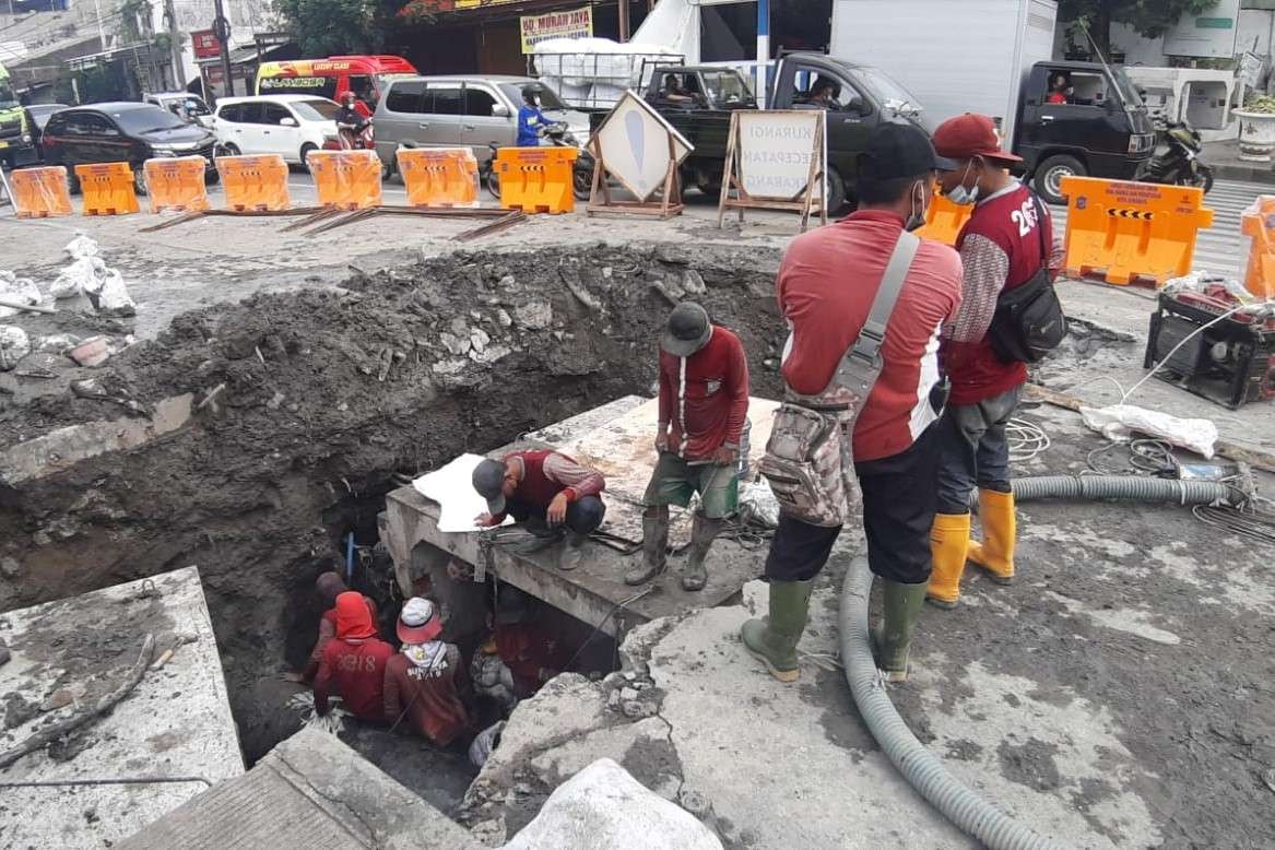 Petugas melakukan pengerjaan pembuatan saluran air di kawasan Kedung Cowek, Surabaya. (Foto: Istimewa)