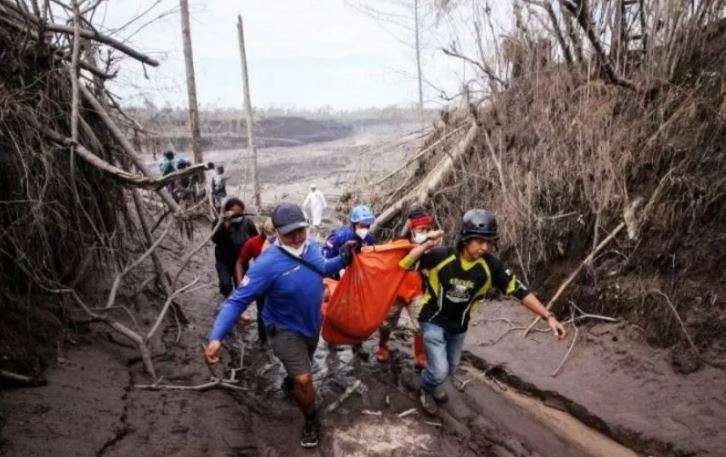 Tim SAR gabungan mengangkat kantong jenazah yang berisi potongan tubuh korban yang ditemukan tertimbun material guguran awan panas Gunung Semeru di Curah Koboan, Pronojiwo, Jawa Timur, Rabu 8 Desember 2021. (Foto: Antara/Umarul Faruq)