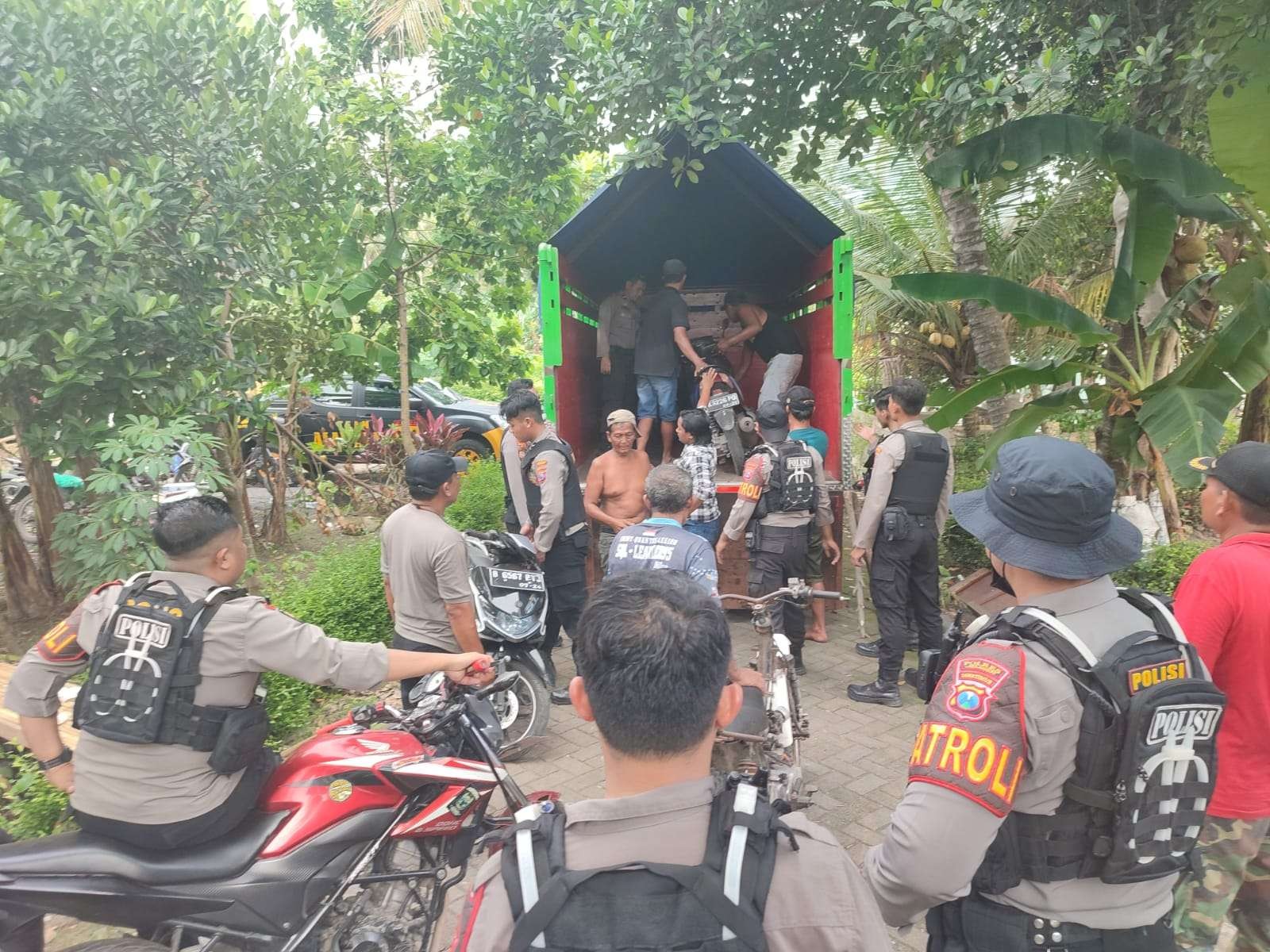 Polisi dibantu warga menaikkan barang bukti ke atas truk (Foto:Istimewa)