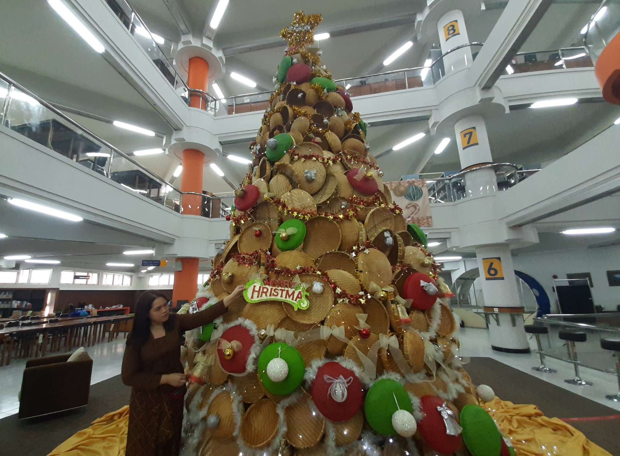 Pohon Natal dari perkakas bambu salah satunya tampah, yang dipamerkan di perpustakaan UK Petra Surabaya. (Foto: Pita Sari/Ngopibareng.id)