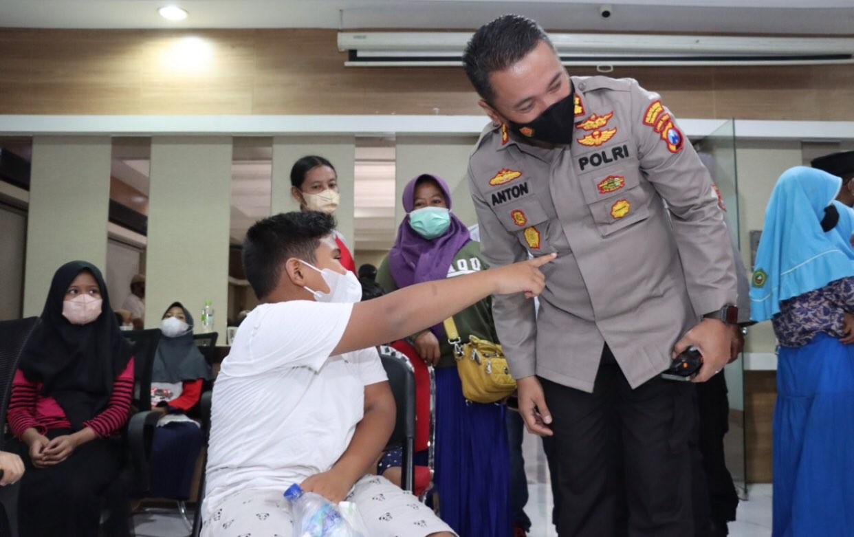 Kapolres Pelabuhan Tanjung Perak, AKBP Anton Elfrino bersama salah satu anak yang hendak divaksin (Foto: dok. Humas Polres Pelabuhan Tanjung Perak)