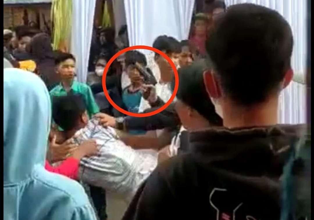 Tangkapan layar video seorang pria tampak mengacungkan benda mirip pistol di arena kesenian jaranan (Foto: Istimewa)