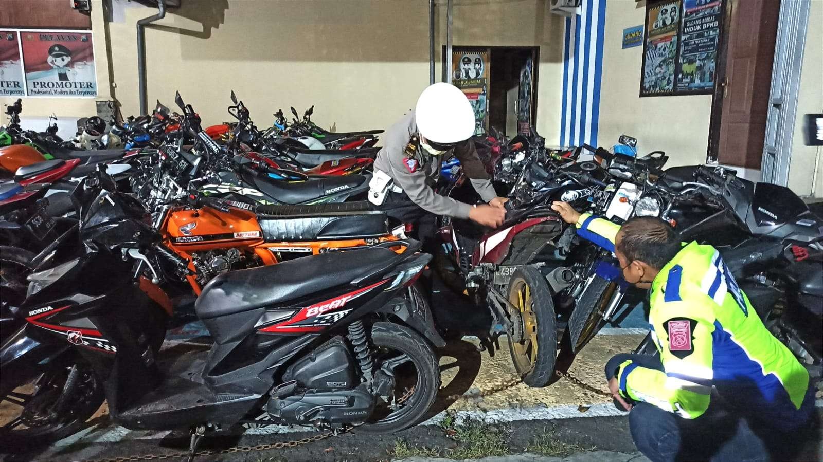 Kasat Lantas Polresta Banyuwangi Kompol Ahmad Fani Rakhim mengecek kendaraan yang menggunakan knalpot brong yang sudah diamankan di Polresta Banyuwangi (foto: Muh Hujaini/Ngopibareng.id)