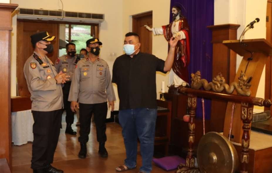 Kapolres Bondowoso AKBP Herman Priyanto  berbincang dengan Pastur David, Pr saat mengecek Gereja Katolik Santo Yohanes Penginjil Bondowoso. (Foto: Guido Saphan/Ngopibareng.id)