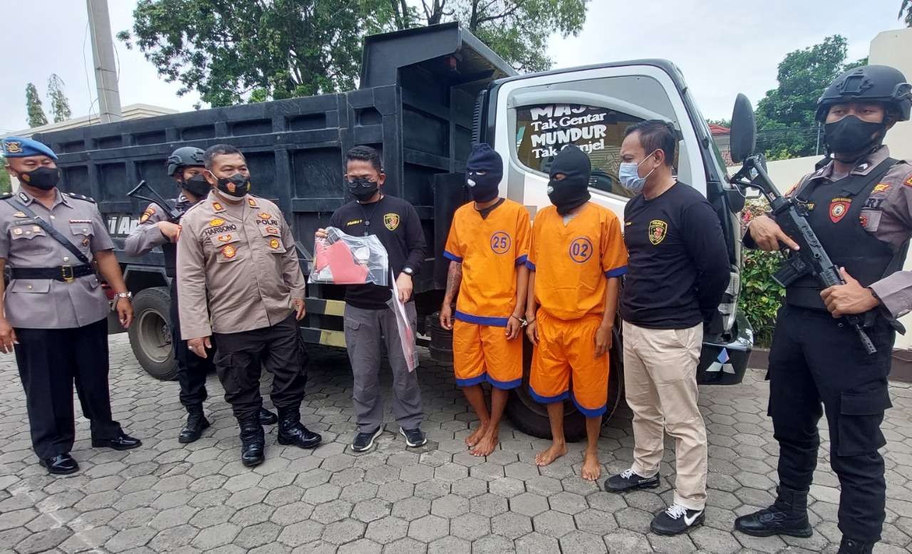 Dua tersangka perampas dump truck pengangkut pasir di Mapolresta Probolinggo. (Foto: Ikhsan Mahmudi/Ngopibareng.id)