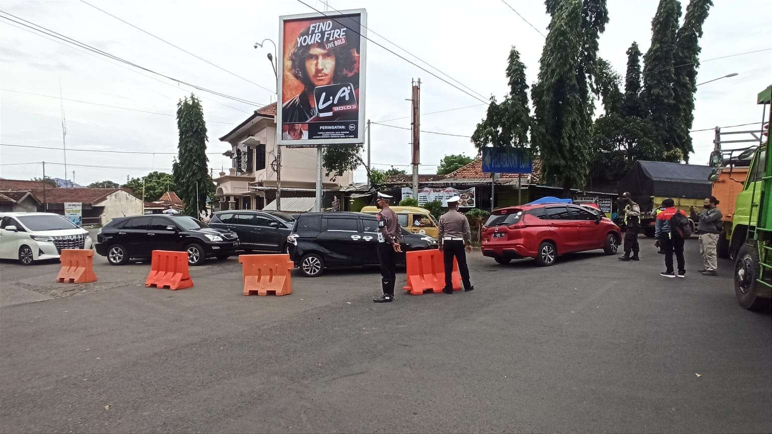 Petugas kepolisian berusaha membuka jalan untuk kendaraan dari Bali yang hendak keluar Pelabuhan Ketapang melalui pintu keluar Dermaga LCM, Senin 3 Januari 2022. (Foto: Muh Hujaini/Ngopibareng.id)