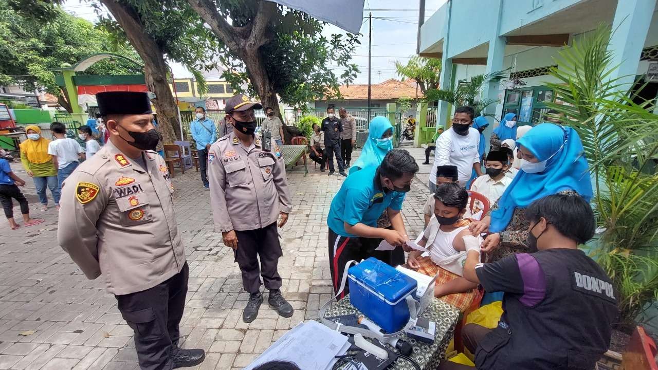 Kapolresta Probolinggo, AKBP Wadi Sa’bani (kiri) saat menyaksikan vaksinasi Covid-19 untuk anak-anak di MI Hidayatullah. (Foto: Ikhsan Mahmudi/Ngopibareng.id)