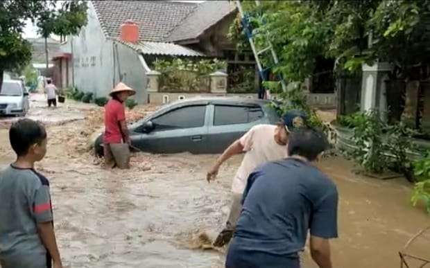 Sebuah mobil terseret arus saat banjir menerjang Kelurahan Mangli, Kaliwates, Jember, Minggu, 09 Januari 2022 (Foto: Istimewa)