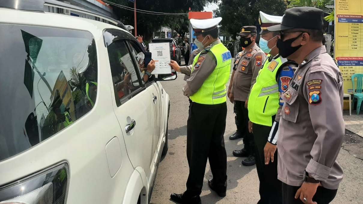 Petugas Polsek Kawasan Pelabuhan Tanjungwangi Banyuwangi melakukan pemeriksaan persyaratan menyeberang di pintu masuk Pelabuhan Ketapang, Banyuwangi. (Foto: Istimewa)